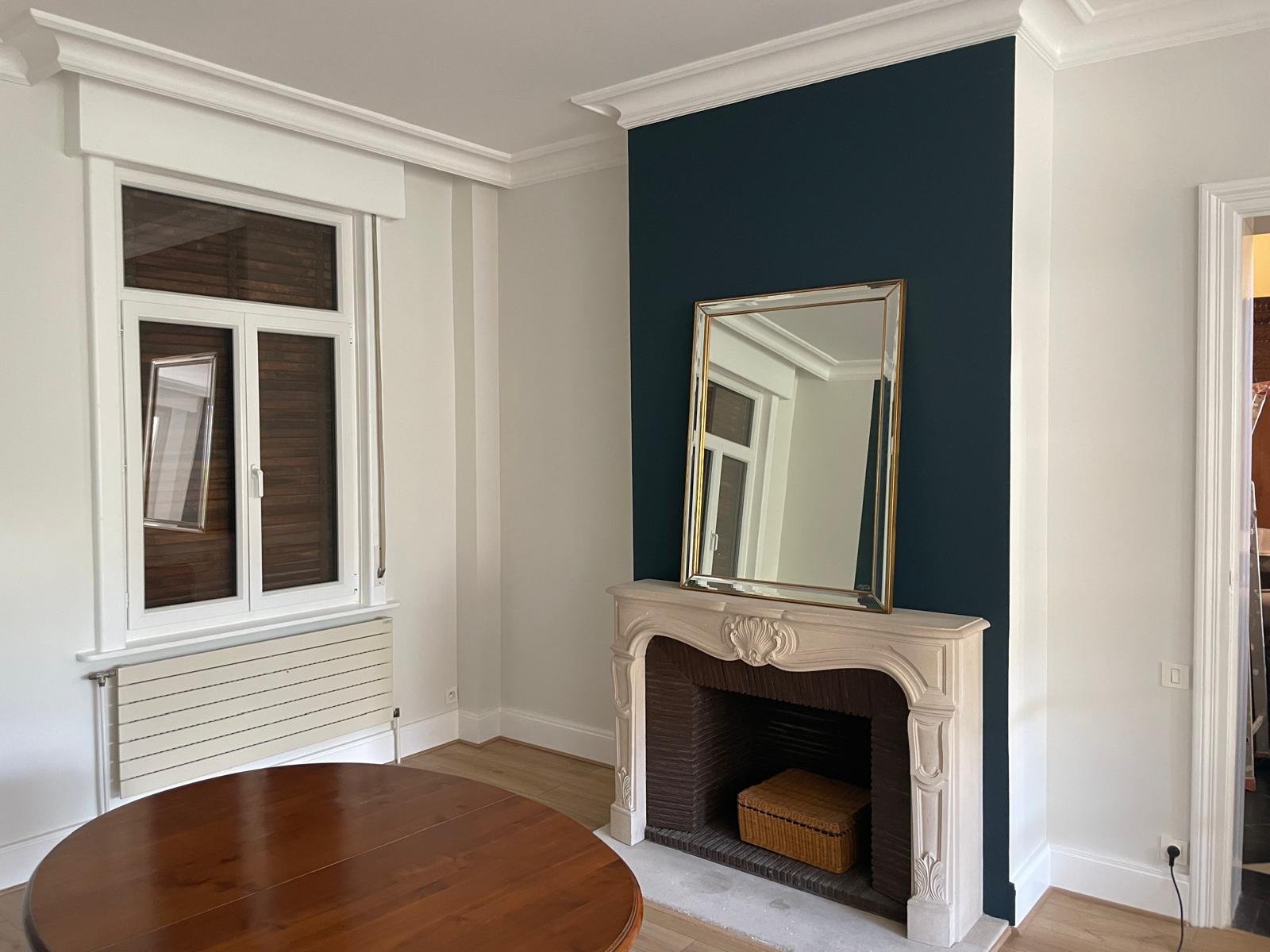 Salle à manger — cheminée en pierre sur un mur d'accent bleu canard
