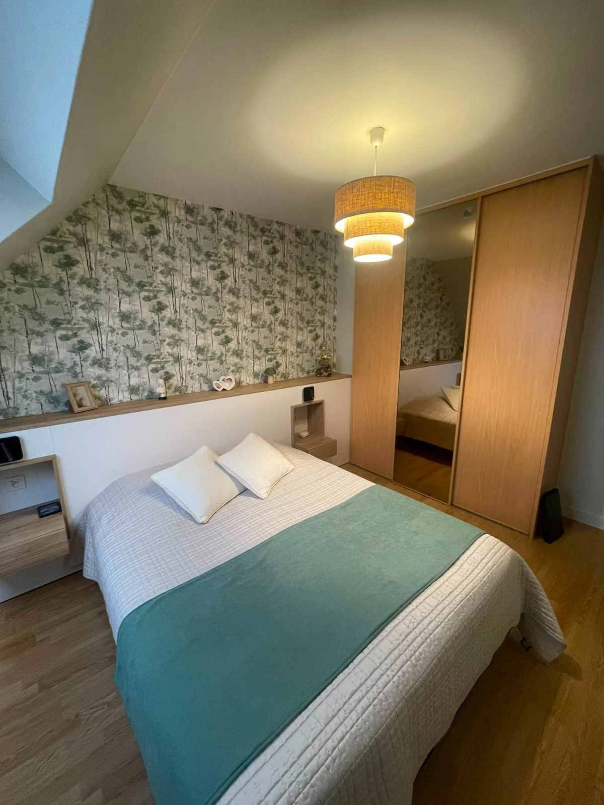 Chambre sous pente — papier peint forêt et dressing à miroir, vue depuis la porte